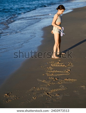 Isolated portrait of a young girl running and playing on the water edge of the sea during sunset- Israel