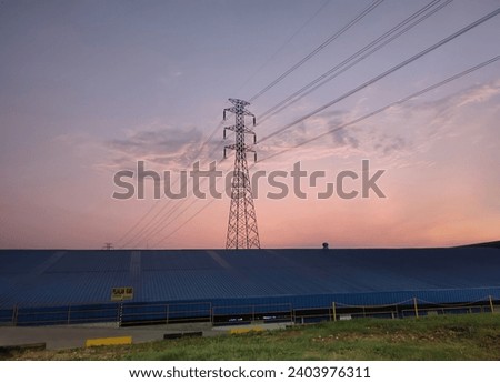 a view of the roof of a building and also a tall electricity pole with a view of the sky in the morning