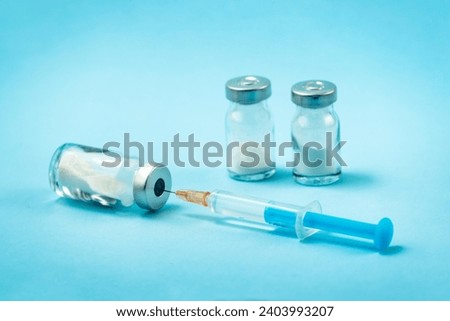 Syringe and needle with glass medical ampoule vials for injection. Medicine is dry white drug penicillin powder or liquid with of aqueous solution in ampulla Royalty-Free Stock Photo #2403993207