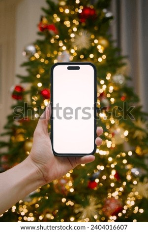 The iphone 15 in a hand  on christmas background