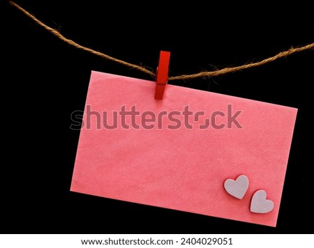 A rustic Valentine's Day card with two wooden hearts hanging from twine.