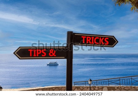 Tips and tricks symbol. Concept word Tips and tricks on beautiful signpost with two arrows. Beautiful blue sea sky with clouds background. Business and Tips and tricks concept. Copy space.