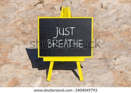Just breathe and psychological symbol. Concept words Just breathe on beautiful black chalk blackboard on a beautiful stone background. Business psychological and Just breathe concept. Copy space