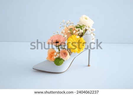 Shoes and colorful spring flowers on a blue background. Summer fashion concept.