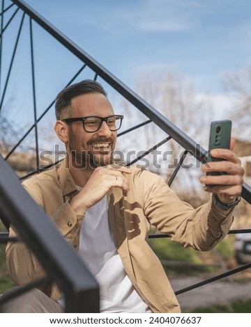 One man happy caucasian male use smart-phone for selfie photo or video call outdoor in front of modern tiny house while on vacation holiday in day real people copy space