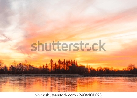 stunning sunrise over winter fros freezing over lake, vivid sky 