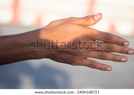 A human hand showing five fingers and blurred background