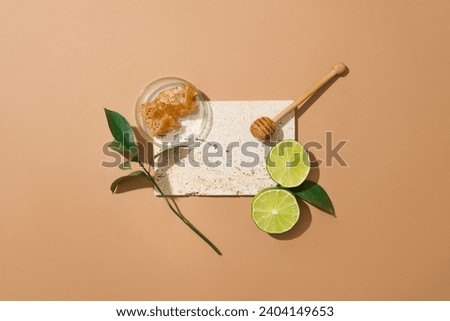 Beeswax contained inside a petri dish, displayed with slices of lime and honey dripping. Empty space on the podium to show product of honey extract