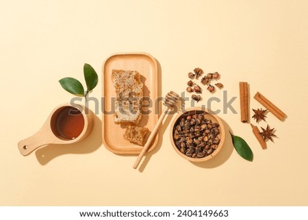 Wooden dish of beeswax arranged with a honey dripping, Cinnamon, star anise, bowls of honey and dried flowers. Commercial photo for branding advertising