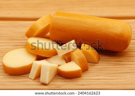 PROVOLONE CHEESE FRONT VIEW ON WOODEN WITH CUT PIECES OF CHEESE ON ISOLATED BACKGROUND Royalty-Free Stock Photo #2404162623