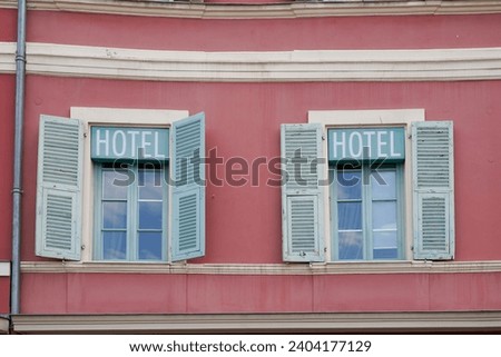 Open shutter made of  green colored wood on a modern wooden window with hotel sign text paint