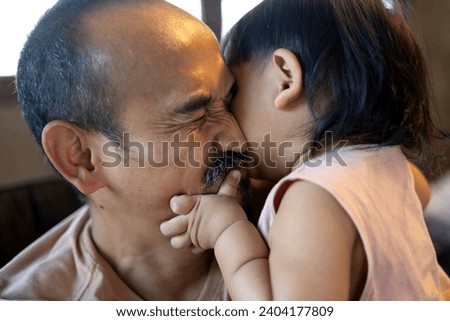 Portrait of Happy father and his son in bedroom. Boy embracing and kiss his Dad.