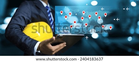 Logistic concept with businessman holding yellow helmet and monitoring tracking industrial cargo shipment on world map flight transportation information to confirm order and prepare production plan Royalty-Free Stock Photo #2404183637