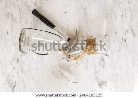 Glass vase crashed with hammer on a marble floor