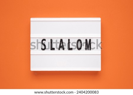The word slalom on lightbox isolated orange background.