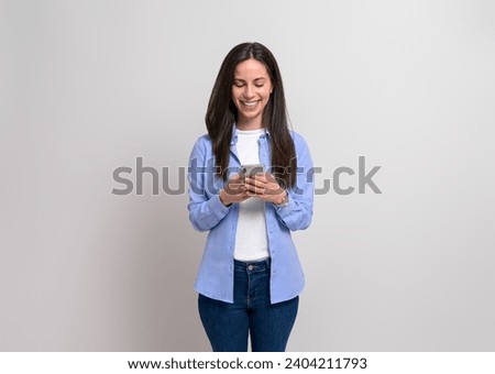 Happy confident businesswoman using social media over smart phone against isolated white background
