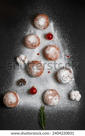 Beautiful Christmas New Year food photo. Dark background. Christmas tree made of sugar and sweet buns. Traditional Ukrainian dessert for Christmas. Pampukhi, donuts with filling and powdered sugar.
