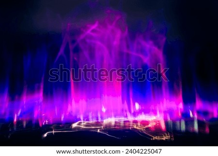 Movement and blurry image of purple and blue lights in the dark, is likely the result of a slow shutter speed