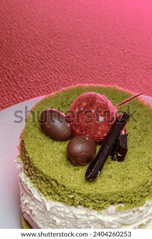 Surface detail of pistachio cake decorated with chocolate and strawberries. Patisserie concept idea.