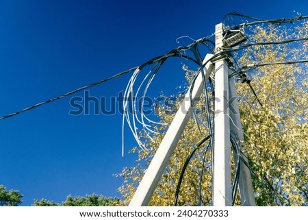 concrete pillar with numerous electrical wires and connectors, serving as an essential component of urban infrastructure and enabling power supply across the city. Royalty-Free Stock Photo #2404270333