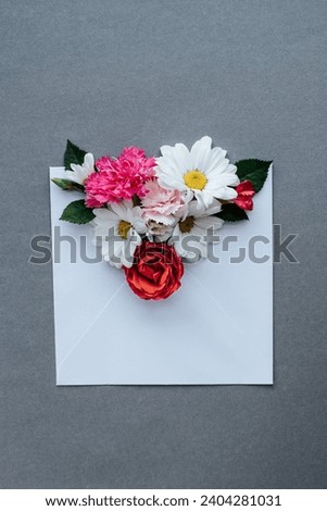 white envelope with flowers on a gray background