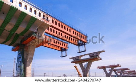 Metal launching gantry Structure for installing concrete typical Segment Joint on foundation of Elevated Expressway in Road Construction site against blue sky  Royalty-Free Stock Photo #2404290749