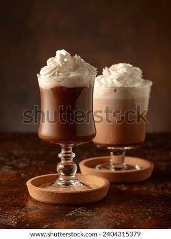 Creamy milk chocolate drinks. Homemade latte with whipped cream on a old brown table. Copy space.