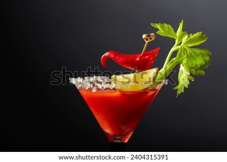 Bloody Mary cocktail with celery, lime, and red pepper. The glass is decorated with sea salt. Royalty-Free Stock Photo #2404315391