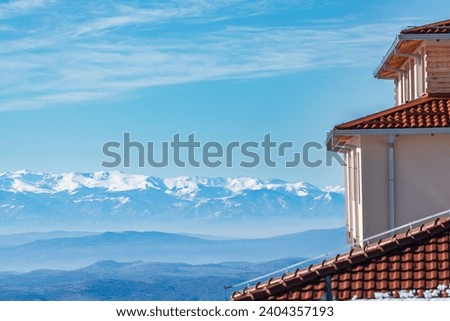 Building architecrure,  rooftop  part of apartment . And mountain peak covered with snow. Magnificent vista. Winter Landscape. 