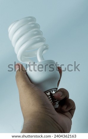 Spiral shaped bulb held in hand isolated on white background