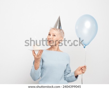 Beauitful elderly female wearing conical hat celebrating birthday