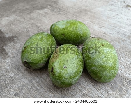 four mangoes on a cement floor with selective focus