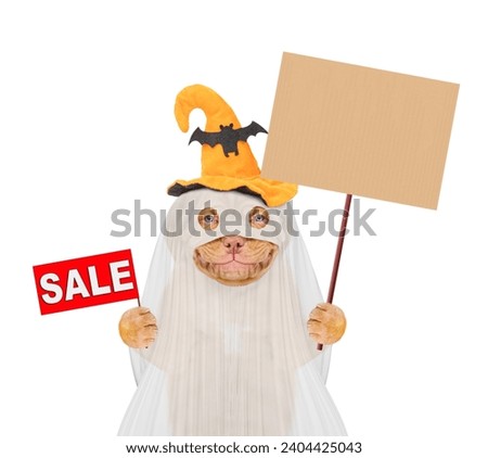 Smiling Mastiff puppy dog celebrating halloween in ghost costume with funny hat  shows signboard with labeled "sale" and empty placard. Isolated on white background