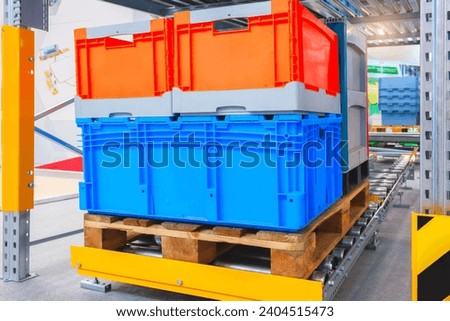 Plastic boxes on a wooden pallet automated conveyor belt in a modern warehouse