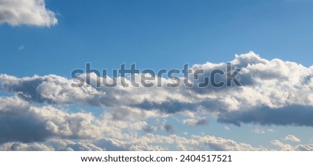Large white clouds covering the panoramic beautiful blue sky. Horizontal sky photo.