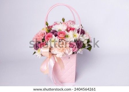 Beautiful bouquet of flowers in pink box on a white background. Gift for holiday, birthday, Wedding, Mother's Day, Valentine's day, Women's Day. Floral arrangement in a hat box.