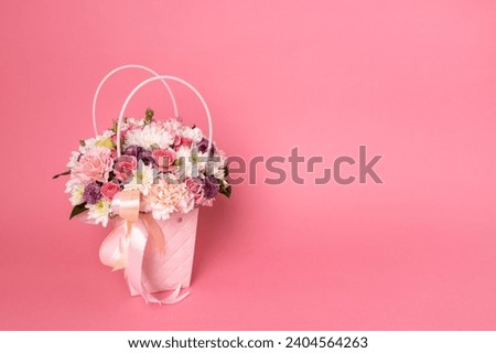 Beautiful bouquet of flowers on a pink background. Gift for holiday, birthday, Wedding, Mother's Day, Valentine's day, Women's Day. Floral arrangement in a hat box. Royalty-Free Stock Photo #2404564263
