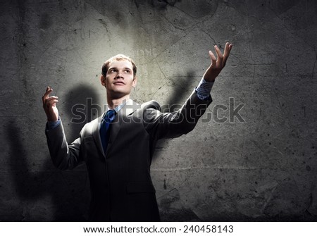 Young handsome businessman in room gesturing with hand