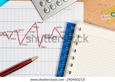 close-up of pen, notebook and graph growth
