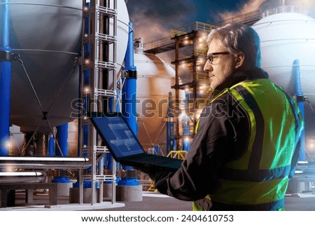 Storage h2. Spherical storage for fuel. Energetics plant under. Innovations power industry. Engineer stands among hydrogen equipment. Mechanic with laptop controls process of obtaining energy.