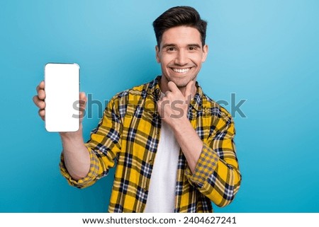 Photo of businessman touch chin smiling feel confident promoting cellphone ad stats his marketing job isolated on blue color background
