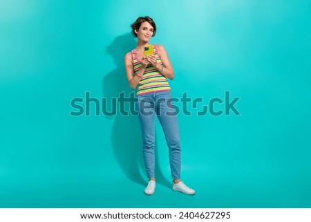 Full size portrait of lovely nice girl hold use smart phone chatting communicate isolated on turquoise color background