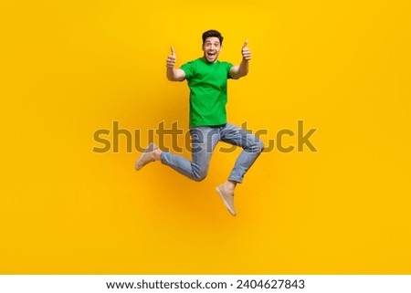 Full length photo of optimistic man dressed green t-shirt run showing thumbs up approve good work isolated on yellow color background