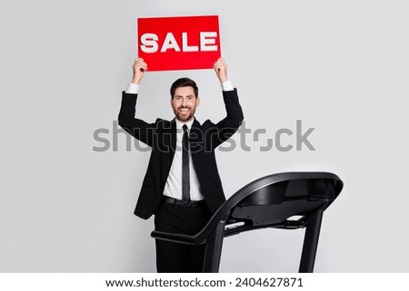 Photo of positive classy person stand treadmill hands hold sale placard empty space isolated on grey color background