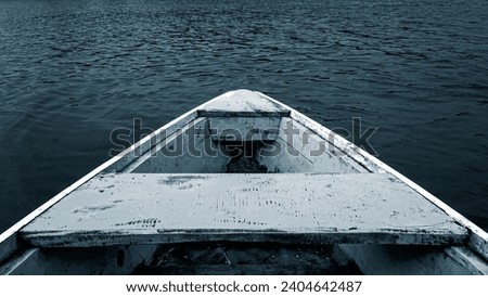 photo of a traditional end of a wooden boat facing the water at the pier. Close up photo