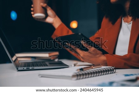 Woman sitting at her desk in home office working late at night using laptop computer; female web designer working overtime remotely from home Royalty-Free Stock Photo #2404645945