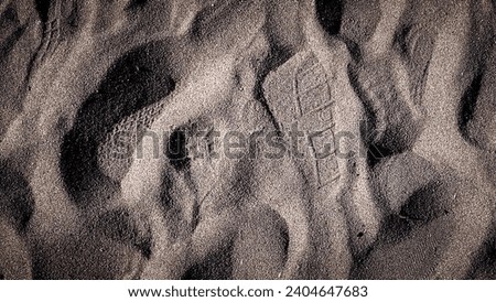 exture of a sand beach with footsteps