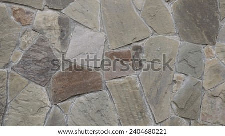 a separate stone in the structure of a building wall, uneven fragments of solid gray granite with a chaotic pattern