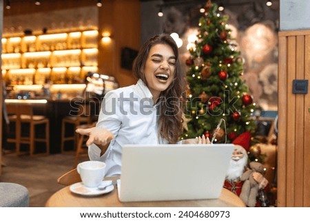 Photo of shiny positive woman with glasses sitting cafeteria drinking coffee and using her laptop for freelance work or online meeting
