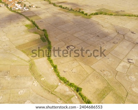Industrial Photography Landscapes. Aerial view of dry rice fields after the harvest period ends, Located in Rancaekek, Bandung - Indonesia. Aerial Shot from a flying drone.
